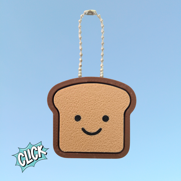 3D-printed sourdough loaf clicker keychain in a bread shape, shown in warm toasty color, used as a stress relief ASMR fidget toy.