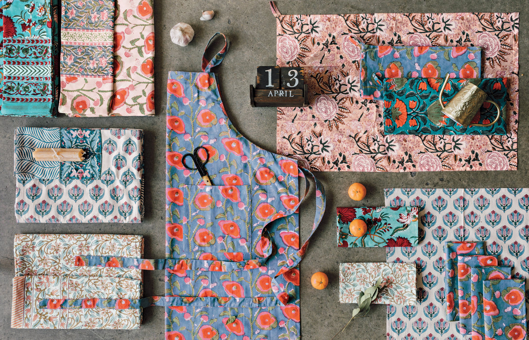 Danica Heirloom Poppy hand block print cotton apron displayed with coordinating kitchen linens and textiles.