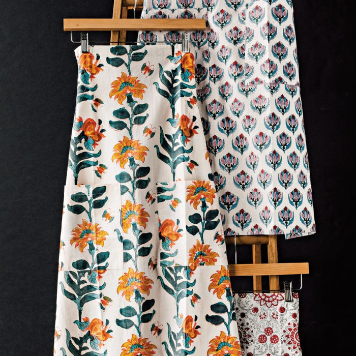 Danica Heirloom Marigold hand block print cotton baking apron displayed with coordinating kitchen linens.