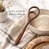 Double loop wooden Danish dough whisk in a bright luxury sourdough kitchen with marble countertops and artisan baking tools for mixing sourdough bread