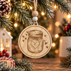 Light natural wood sourdough starter jar Christmas ornament with a laser-engraved mason jar and heart design, hanging from an evergreen branch with warm holiday lights.