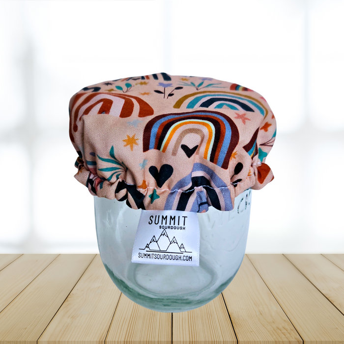 Pink rainbow fabric cover on a sourdough starter jar