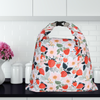 Floral and strawberry patterned bag on a kitchen counter with white tiles in the background